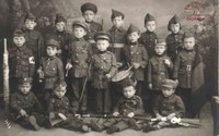 Carte postale. Classe de garçons de l'école Saint-Joseph à Auvelais, déguisés en soldats pour le défilé patriotique  du 7 septembre 1919 en l'honneur des Combattants d'Auvelais.