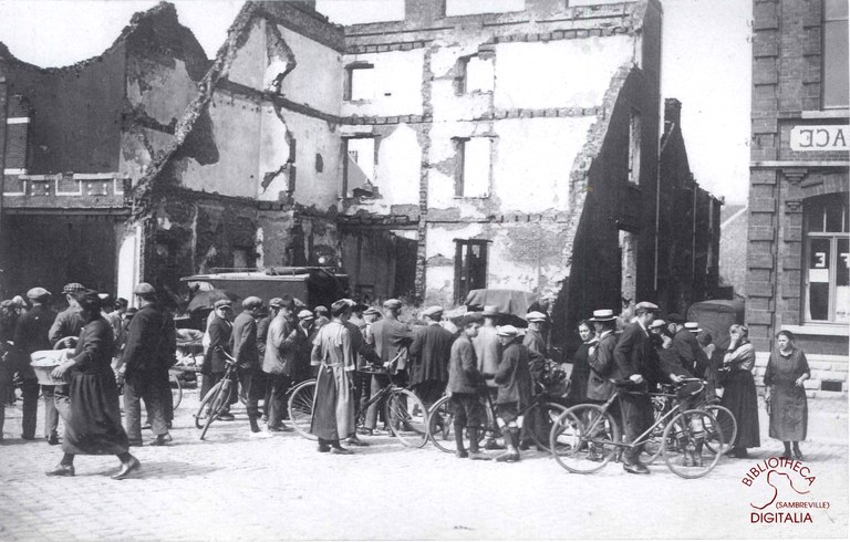 Groupe de personnes devant les décombres d'une maison à Tamines